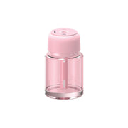 A pink Green Lion fragrance air diffuser with a clear glass body and a pink lid.